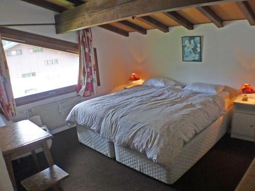une chambre avec un grand lit et une fenêtre dans l'établissement Duplex 4 pièces à Samoëns avec balcon et WiFi inclus - FR-1-629-3, à Samoëns