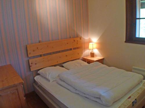 une chambre avec un grand lit avec une tête de lit en bois dans l'établissement Appartement 3 pièces avec parking et vue montagne à Samoëns - FR-1-629-52, à Samoëns
