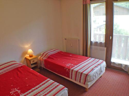 deux lits dans une chambre avec une fenêtre dans l'établissement Charmant T2 près de la patinoire de Samoëns - Balcon Sud, Animaux admis - FR-1-629-70, à Samoëns