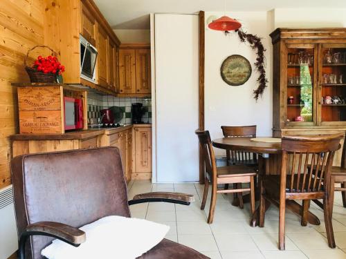 - une cuisine avec une table à manger et des chaises dans l'établissement Coquet T2 avec terrasse plein sud, au centre de Samoëns, proche commerces et ski-bus - FR-1-629-79, à Samoëns