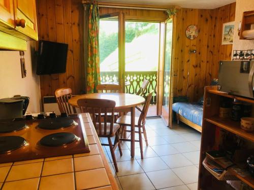 une cuisine et une salle à manger avec une table et des chaises dans l'établissement Appartement cosy avec balcon, parking et animaux acceptés - FR-1-629-90, à Morillon