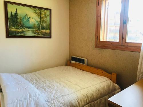 une chambre avec un lit et un tableau au mur dans l'établissement Appartement cosy avec balcon, parking et animaux acceptés - FR-1-629-90, à Morillon