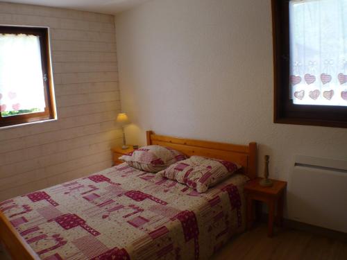 een slaapkamer met een bed met een quilt bij Appartement Samoëns, 2 pièces, 6 personnes - FR-1-629-16 in Samoëns