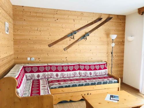 un lit dans une chambre avec un mur en bois dans l'établissement Appartement avec piscines, parking et WiFi à Samoëns - FR-1-629-25, à Samoëns