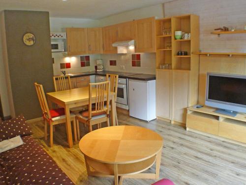 une cuisine et une salle à manger avec une table et une télévision dans l'établissement Studio confortable face aux télécabines, proche loisirs avec parking et animaux admis à Samoëns - FR-1-629-54, à Samoëns