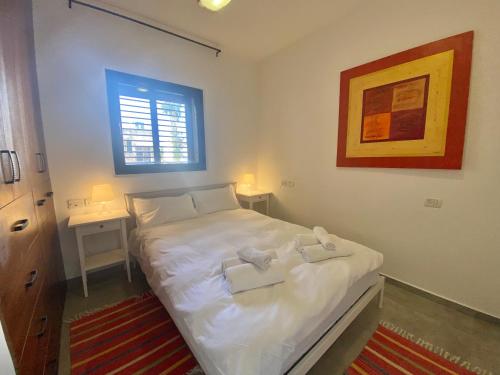 a bedroom with a bed with two towels on it at Lapin 9 - By Beach Apartments TLV in Tel Aviv