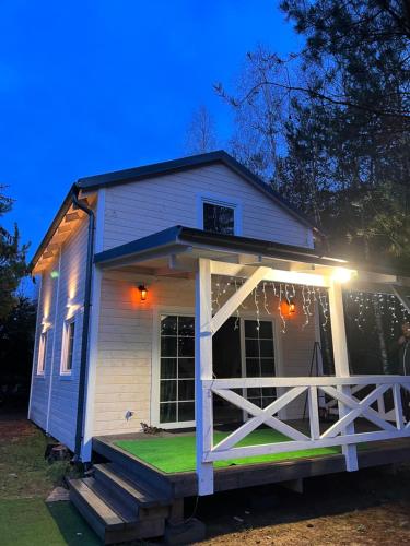 a tiny house with a porch at night at Domki na Kaszubach u Madzi in Grabówko
