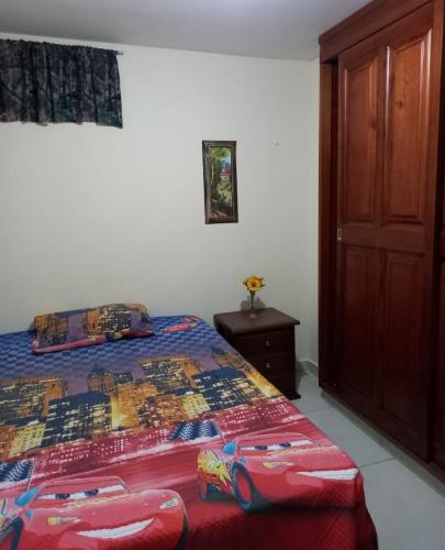 1 dormitorio con 1 cama y puerta de madera en Casa Gloria, en Medellín