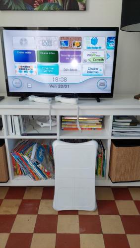TV a/nebo společenská místnost v ubytování Le So Wild, maison avec jardin clos, terrasse aménagée, 5 mn à pied commerce, terrain de tennis, à 800 m de la plage d'Omaha beach jeux arcade, jouets, matériel jeunes enfants enfants, table ping-pong