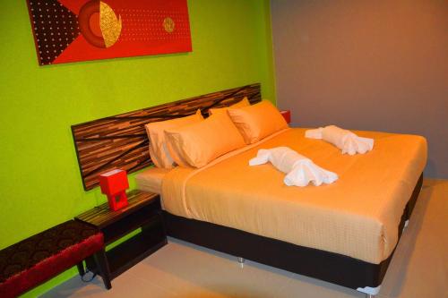a bedroom with a bed with two towels on it at Dwella Suvarnabhumi in Lat Krabang
