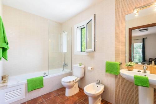 uma casa de banho com um WC, um lavatório e um espelho. em SolParc 589 em Son Parc