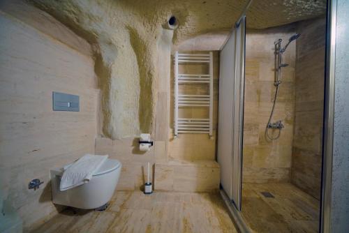 a bathroom with a shower and a tub and a toilet at Babili Cappadocia Cave in Nevşehir
