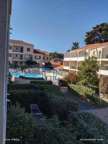 - une vue sur un bâtiment et une piscine dans l'établissement T2 en résidence avec piscine, à Saint-Jean-de-Monts