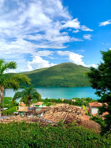 a view of a lake with palm trees and a mountain at Mirante do Lago in Capitólio