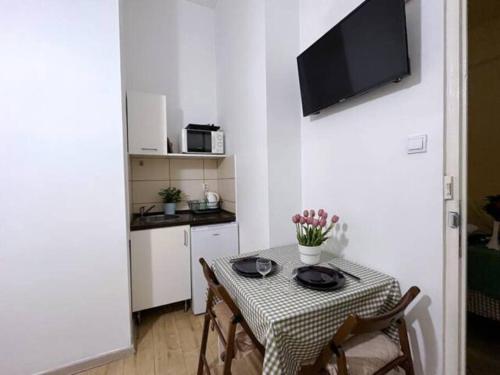 a small kitchen with a table with chairs and a television at A4 Parliament Sunflower Cozy Apartment in Budapest