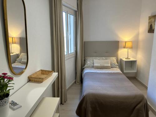 um pequeno quarto com 2 camas e um espelho em Malagueta Beach Premium em Málaga