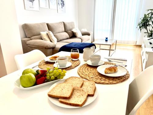 a breakfast table with bread and fruit on it at Apartamento Mirando al Guadiana Centro in Ayamonte