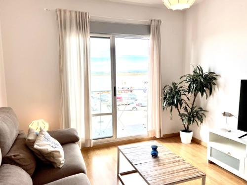 a living room with a couch and a large window at Apartamento Mirando al Guadiana Centro in Ayamonte