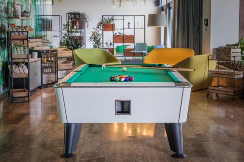 a pool table in a room with chairs at Parkhotel Brenscino Brissago in Brissago