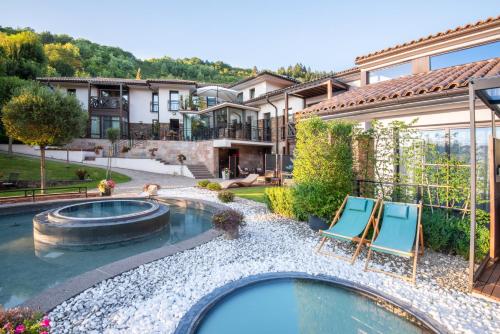 a backyard with a pool and two chairs and a house at Villa Helia in Dolný Kubín
