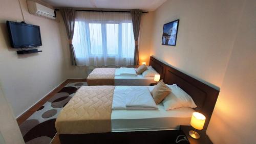a hotel room with two beds and a television at Hotel Villa Panorama in Belgrade