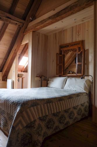 une chambre avec un grand lit avec un plafond en bois dans l'établissement Les Jardins de la Contie, à Lunan