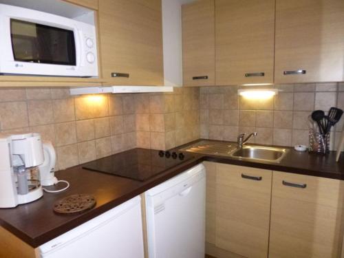une cuisine avec un évier et un micro-ondes dans l'établissement Studio cosy avec balcon, 4 pers, Brides-les-Bains, WIFI, parking couvert, animaux bienvenus - FR-1-512-85, à Brides-les-Bains