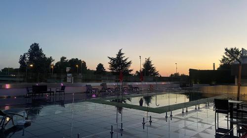 - une piscine avec des chaises et un coucher de soleil en arrière-plan dans l'établissement Mercure Orléans Centre Bords de Loire, à Orléans