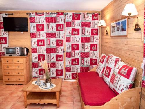 un salon avec un canapé et un mur de photos dans l'établissement Studio 4 Pers. avec Balcon, Résidence Les Chalets de Praroustan, Pra Loup 1500 - FR-1-504-367, à Uvernet