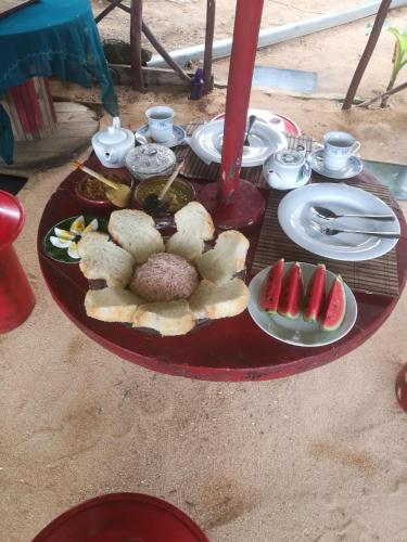 a red table with plates of food on it at Rosa Shashi Cabanas in Galle