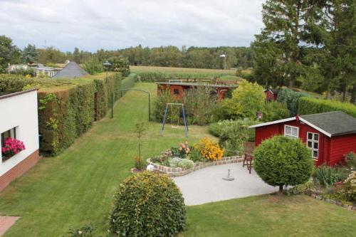 a garden with a playground and a red house at Ferienwohnung im roten Haus in Stahlbrode