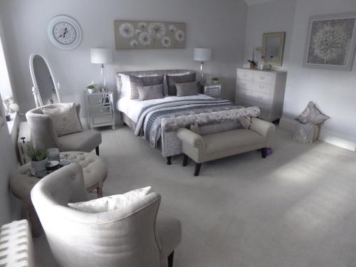 a bedroom with a bed and two chairs and a dresser at The Skreen in Builth Wells