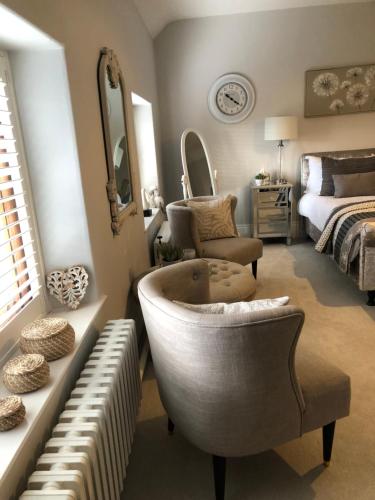 a bathroom with a tub and a bed and a chair at The Skreen in Builth Wells