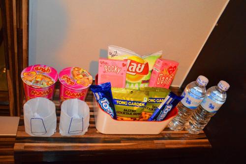 a table with a bunch of snacks and water bottles at Dwella Suvarnabhumi in Lat Krabang