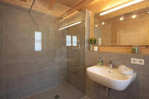 W łazience znajduje się umywalka i prysznic. w obiekcie Chalet Chiemgau w mieście Schleching
