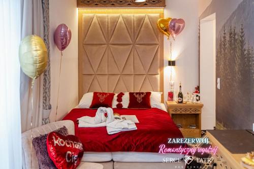 a bedroom with a red bed with balloons on it at Serce Tatr Residence Zakopane - blisko Krupówek in Zakopane