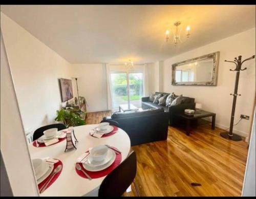 ein Wohnzimmer mit einem weißen Tisch und einem Sofa in der Unterkunft Royal Arsenal Riverside Apartment in London