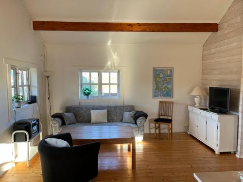 ein Wohnzimmer mit einem Sofa und einem Tisch in der Unterkunft Hovborg Ferieby - Torpet 126 in Hovborg