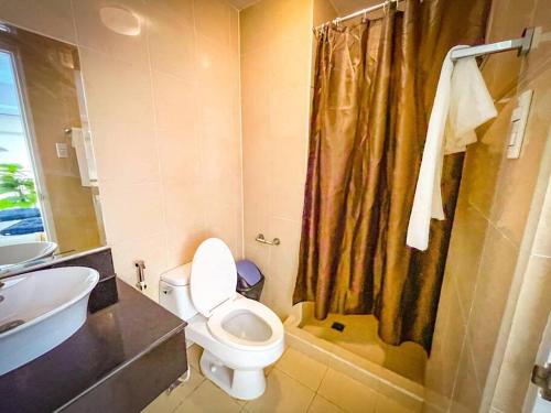 ein Bad mit einem WC, einem Waschbecken und einer Dusche in der Unterkunft Lovely 1BR Loft in BGC Golf View in Manila