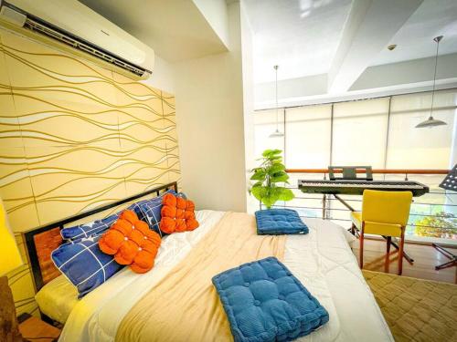 ein Schlafzimmer mit einem großen Bett mit blauen und orangefarbenen Kissen in der Unterkunft Lovely 1BR Loft in BGC Golf View in Manila