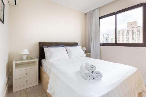 Un dormitorio con una cama blanca con toallas. en Flat no estilo! 14 andar, AC, Piscina, Academia, en São Paulo