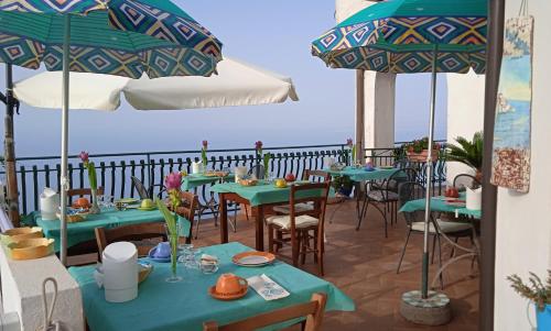 un restaurante con mesas y sombrillas en el balcón en Astra en Agerola