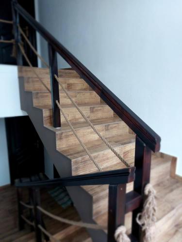 a wooden staircase with a black rail and wooden floor at Casa Calea Haiducilor in Sohodol