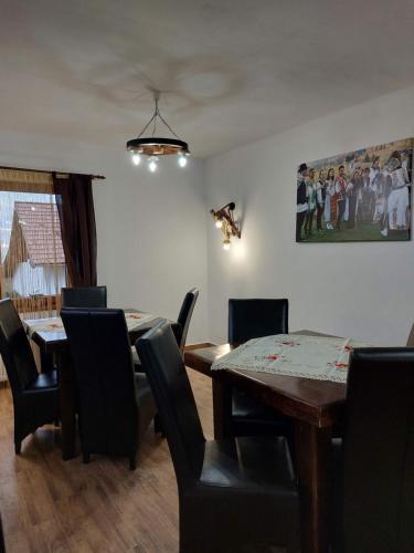 a dining room with tables and chairs and a painting at Casa Calea Haiducilor in Sohodol