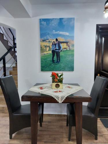 een eettafel met een foto aan de muur bij Casa Calea Haiducilor in Sohodol