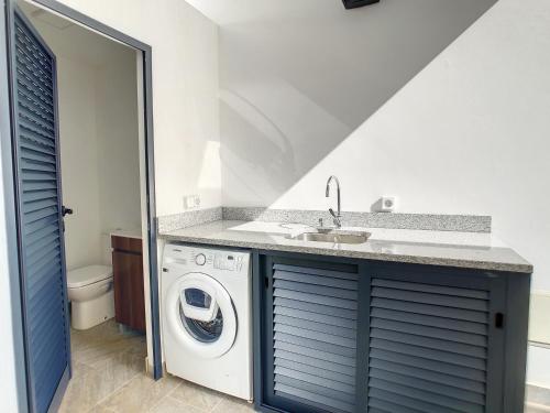 a bathroom with a washing machine and a sink at Casa Erbozeta by LovelyStay in Funchal