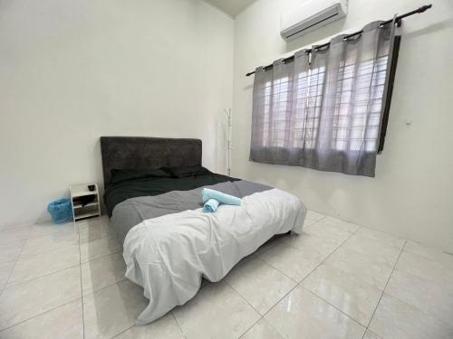 1 dormitorio con 1 cama en una habitación blanca en Ngio Batu Pahat Homestay, en Batu Pahat