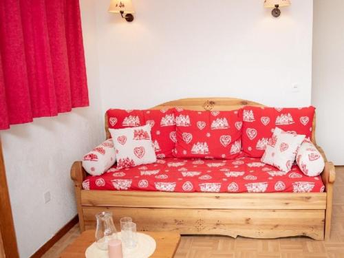 a red couch with white pillows in a room at Appartement Puy-Saint-Vincent, 3 pièces, 6 personnes - FR-1-504-81 in Puy-Saint-Vincent