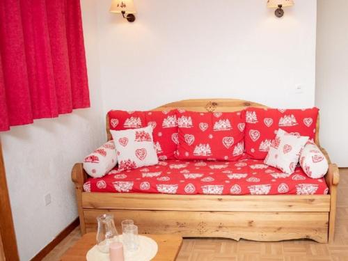 ein rotes Sofa mit weißen Kissen in einem Zimmer in der Unterkunft Appartement Puy-Saint-Vincent, 3 pièces, 6 personnes - FR-1-504-106 in Puy-Saint-Vincent