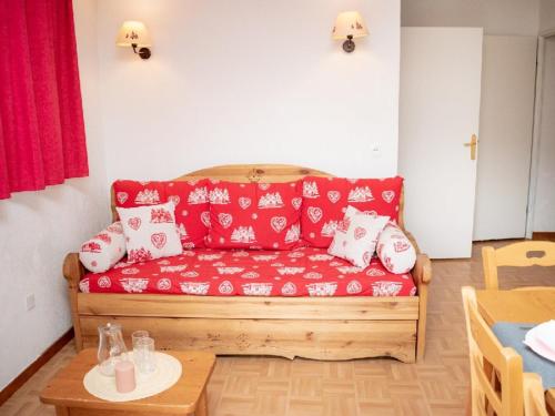 - un canapé rouge dans le salon avec une table dans l'établissement Charmant appartement 3 pièces pour 6 personnes avec balcon proche des pistes à Puy-Saint-Vincent - FR-1-504-145, à Puy-Saint-Vincent